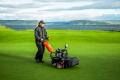 A Jacobsen Eclipse 2 mower on the 1st green, with a spectacular view across the Moray Firth