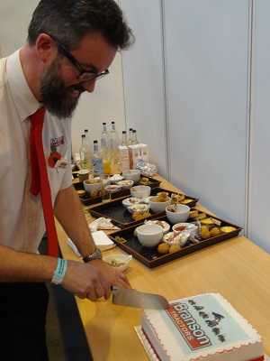 Branson Tractor's md Nathan Walker, cutting a cake celebrating the company's first birthday