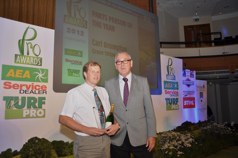 Carl Brumpton (left)collects his parts person of the year award from Luke Volknandt of Briggs and Stratton