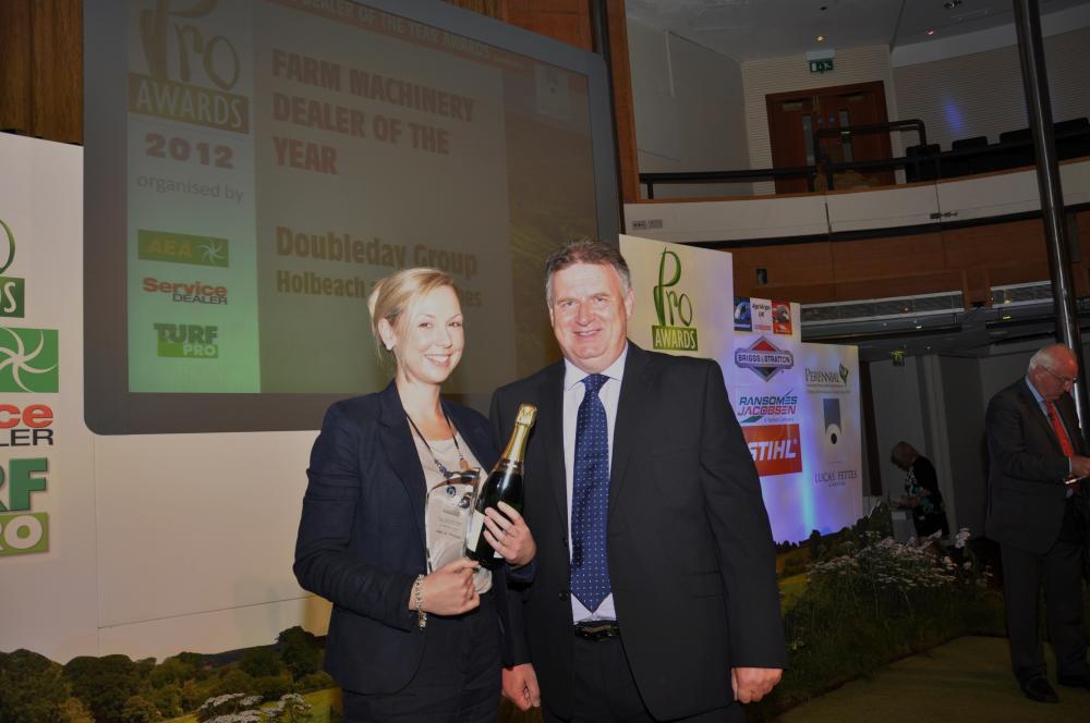 Zoe Doubleday-Collinson of the Doubleday Group collects the farm machinery dealer of the year award from Sandy Brownlee of Lucas Fettes