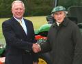 Sir Jackie Stewart OBE shakes hands on the new John Deere 4720 compact tractor deal with dealer Farol's groundcare sales manager Peter Helps