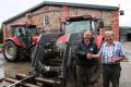 Merfyn Edwards (right) receives a celebratory bottle of whisky from Terry Hughes, managing partner of HJR Agri (Oswestry) Ltd, after purchasing the 100th McCormick tractor supplied by the dealership.
