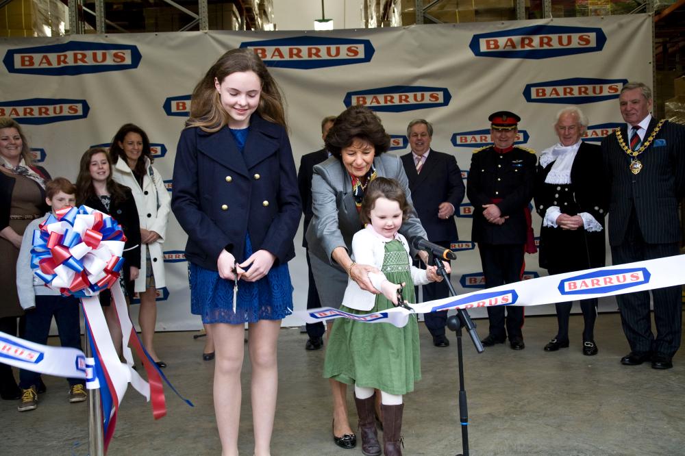 Granddaughters Gabriella Hart (with scissors) and Olivia Newall cut the ribbon