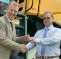 BBC Countryfile presenter Adam Henson takes delivery of his New Holland CR 9070 combine harvester from Adrian Lovegrove of T H White at the Royal Three Counties Show