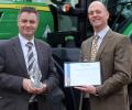 John Deere Limited marketing manager Chris Wiltshire (left) receives the 2016 Farmers Guide Award for Excellence from machinery editor David Williams