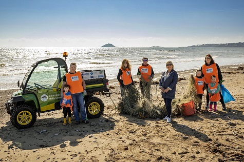 Pictured with the new John Deere Gator on Ardnahinch beach, Co Cork are (far left) four year old volunteer Odhran Ó Tuama with his father Proinsias, Mayor Cllr Mary Linehan Foley and other Clean Coasts Ballynamona volunteers. (Photo credit: Cathal Noonan)