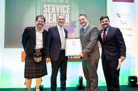 Adam Giles, Account Manager, Ibcos (2nd from right) presents Neale Hopley of Buxtons with their Forestry Machinery Dealer of the Year award at 2019's Service Dealer Awards - with Service Dealer owner Duncan Murray-Clarke (left) and comedian Charlie Baker (right)