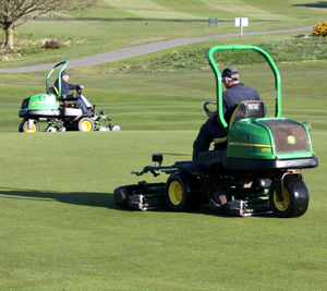 Two of the John Deere 2500E electric hybrid greens mowers at work on this traditional heathland course