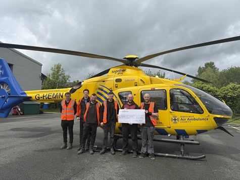 Members of the team present North West Air Ambulance with a cheque for £10,856